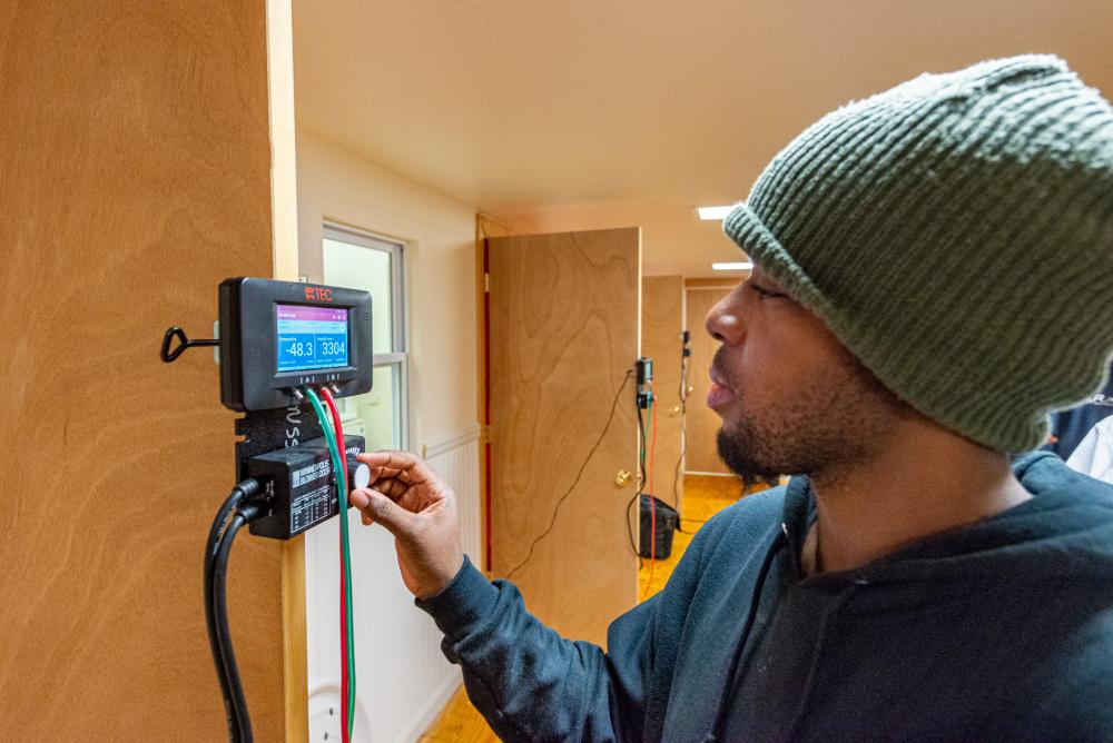 A student modifies settings in a controller for a blower test