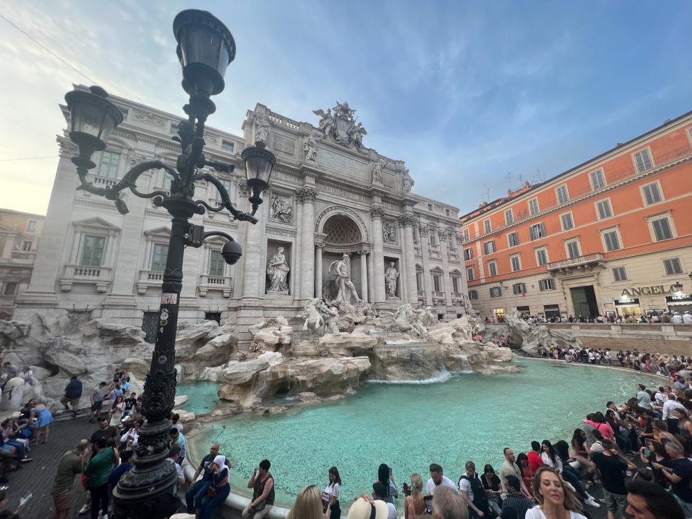 Historic Italian building with large fountain. 