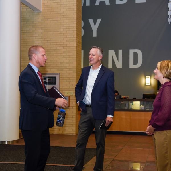 Pittman is welcomed by Reed and Kline in the lobby of the Davie Jane Gilmour Center.