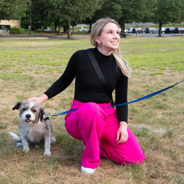 A student pats a dog's head.