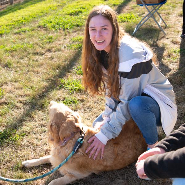 A student pets a dog.