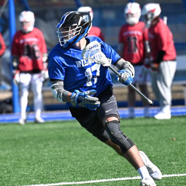 A lacrosse player, in uniform, runs during a game.