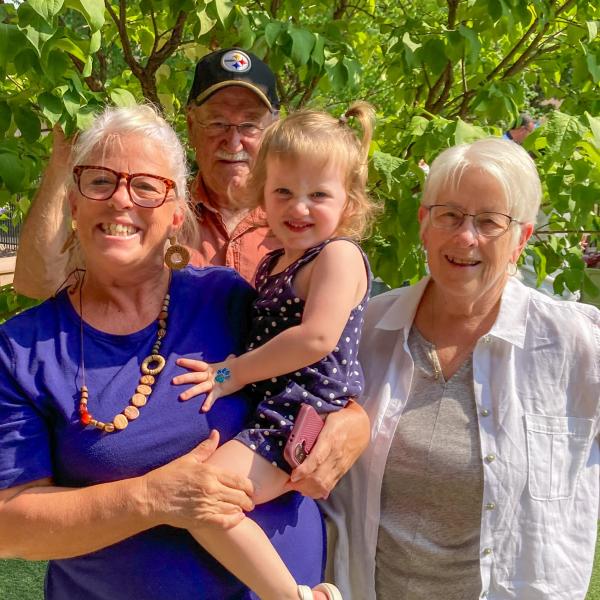 Three grandparents with their grandchild.