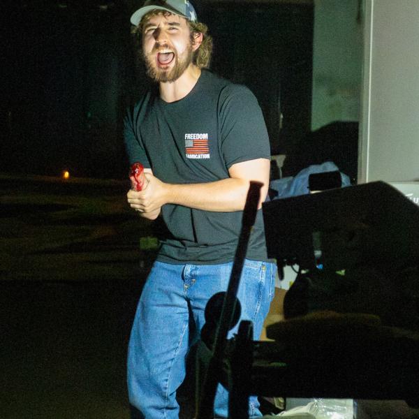 A student screams as he holds his arm, made up to look like his hand was just cut off.
