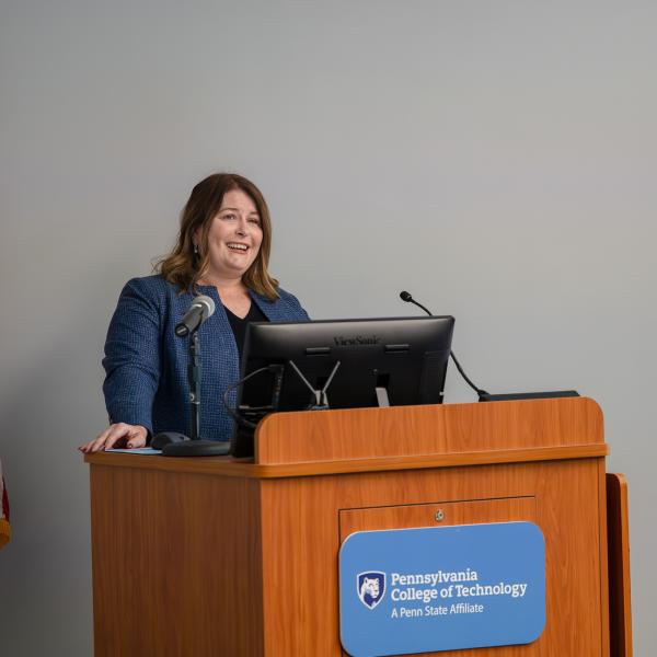 A speaks from behind a podium in Penn College's Thompson Professional Development Center.