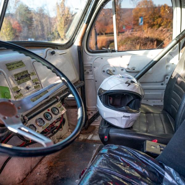 A white racing helmet sits on the passenger seat inside the cab of the Penn College Diesel Performance Club's 1959 Mach drag-racing truck.