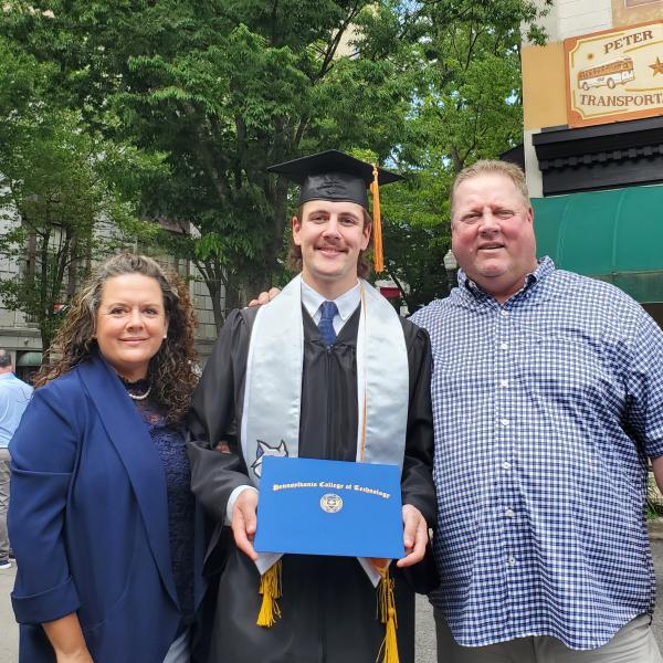 Walt standing downtown Williamsport with his parent after graduation.