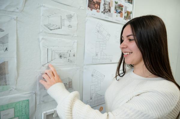architecture student displays and points to her work