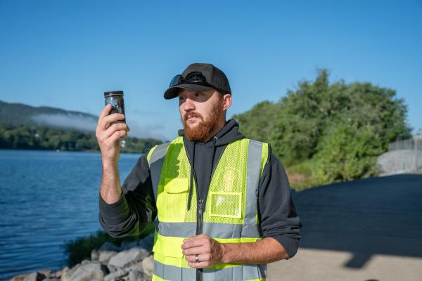 civil engineering student studies soil during river field work