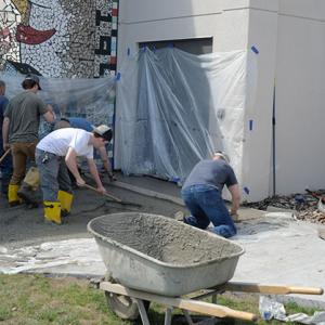 Reber (left) and his students work outside the main entryway, which was temporarily relocated to the south side of the PAC.