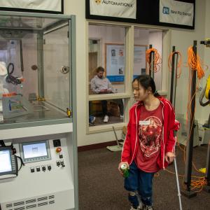Ken J. Kinley, assistant professor of electronics, shows a student-programmed robot in action.
