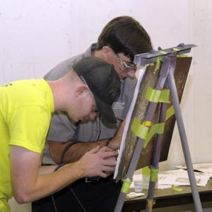 Fine-tuning their skills at the easel are automotive restoration students Kyle W. Godin (in yellow shirt), of Allport, and Alex Riddle, of Kingston, Mass. Each earned degrees in May: Godin in collision repair technology and Riddle in automotive technology.