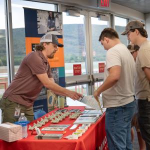 An employer hands information to a student.