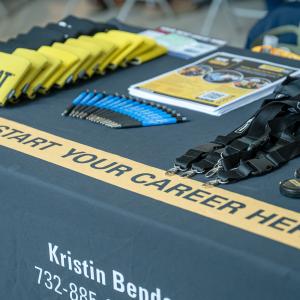 Giveways and printed information on an employer's table. A banner reads "Jump Start Your Career Here."
