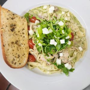 A pasta dish with greens and tomatoes.