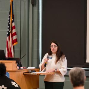 A woman speaks into a microphone.