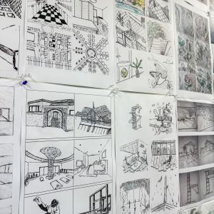 A wall is covered by 5-inch-by-five-inch architecture-related sketches.