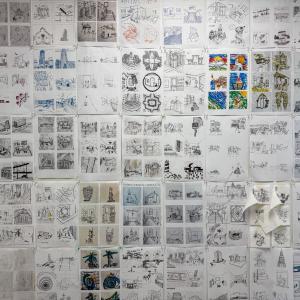 A wall is covered by 5-inch-by-five-inch architecture-related sketches.