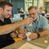 Keith Cremer (left), an eighth-grade science teacher in the South Williamsport Area School District, and Dan Zerbe, who teaches STEM and other courses in the East Lycoming School District, strategize to use materials on hand to slow down the vessel that they’ve designed to carry an egg from a second-floor balcony to the ground level.