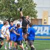 Goalkeeper Malcolm P. Kane (in black shirt) goes skyward on defense, rising above the crush of competition.
