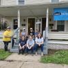 Community-minded Admissions co-workers pause on the porch at 663-665 Center St. in Williamsport in the midst of their labors.