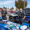 During an open house prior to the Employee Engagement event, a student interacts with David C. Pletz, chief of police and director of campus safety, and Officer Catherine J. Farr.