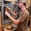 Thomas A. Romine, a building automation engineering technology student from Carlisle, works on one of the load centers donated to Pennsylvania College of Technology by Siemens Smart Infrastructure. The company provided the college with 21 125-amperes load centers containing a variety of circuit breakers.
