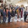 People in business suits gather on the steps of the Pennsylvania Capital Rotunda. In front is a man speaking at a podium.