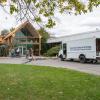 A Pennsylvania College of Technology Construction/Design Technologies truck sits in front of the Scheebeli Earth Science Center while masonry students work at the building's entrance.