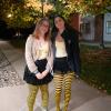 Two young women stand together wearing bee costumes.