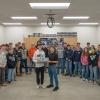 A group of students from Miffling County Aacademy of Science and Technology stands in a Penn College electrical lab. Two in the center are holding a piece of electrical equipment.