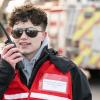 Student Mikya Stake speaks into a walkie talkie while wearing a red emergency vest.