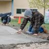 Students use trowels to smooth concrete in front of Penn College's Bush Campus Center.