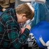 A Scout uses dental tools on a model of a mouth during a past Merit Badge College at Pennsylvania College of Technology.