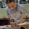 A student wearing eye protection operates a lathe in Penn College's Larry A. Ward Machining Technologies Center.