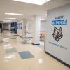 A wall at the entry of an open space with tile floors, tables and chairs and white boards has a Wildcat logo and says "Wildcat Math Hub. Think. Collaborate. Innovate."
