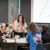 A woman interacts with students who are seated at a round table Penn's Inn at Penn College.