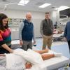 People gather around a medical manikin lying in a hospital bed in Penn College's Physician Assistant Center.