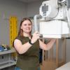 Kelsey Bennett with hands on X-ray equipment in Penn College lab.