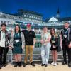 Six Penn College students stand near the paddock at Churchill Downs. One of the facility's iconic spires is visible behind them.