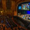 A student in graduation cap and gown accepts a diploma folder from Penn College's president on the Journey Bank Community Arts Center stage.