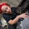A student looks under a vehicle hood.