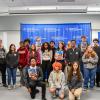Eighteen students and two adults stand and neal in front of a Pennsylvania College of Technology step-and-repeat banner.