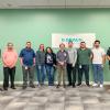A group of 10 people stands in front of a green wall that has a B. Braun sign hanging on it.