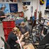 Penn College students reassemble a single-seat off-road vehicle in the college's Baja Room. They are surrounded by toolboxes.