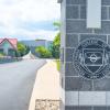 A gray brick pillar at Penn College's main entrance displays the college seal.