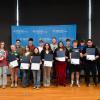 Fifteen high school students, joined by two Penn College Workforce Development staff members, stand in front of a Penn College step-and-repeat banner in the college's Penn's Inn. The students are holding certificates.