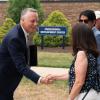 Penn College President Michael J. Reed shakes the hand of a Penn State Board of Trustees member. Visible in the background is a sign for Penn College's Thompson Professional Development Center.