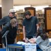 A family meets with a Penn College representative during Open House check-in at the college's Madigan Library.