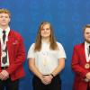 Three young men wearing SkillsUSA medals stand before a blue backdrop. Two are wearing red SkillsUSA jackets.